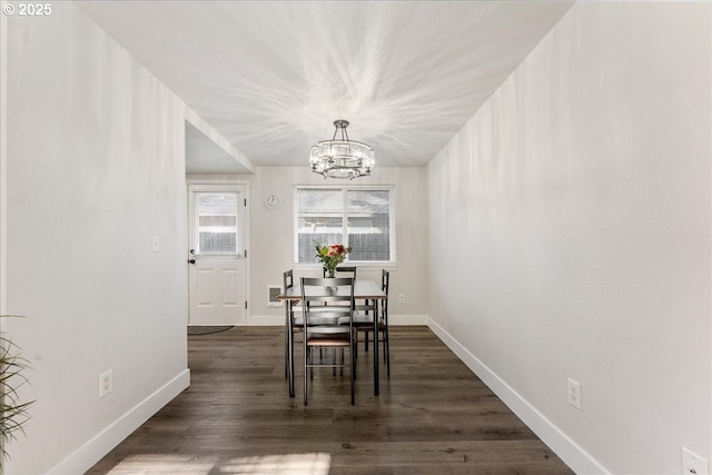 dining area featuring a notable chandelier and dark hardwood / wood-style flooring