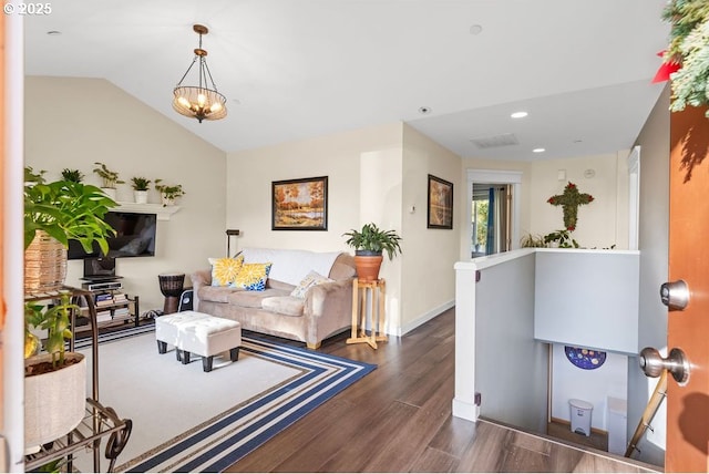 living room featuring dark wood-type flooring, lofted ceiling, and a chandelier