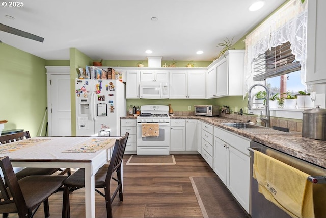 kitchen with sink, white cabinetry, white appliances, light stone countertops, and dark hardwood / wood-style flooring