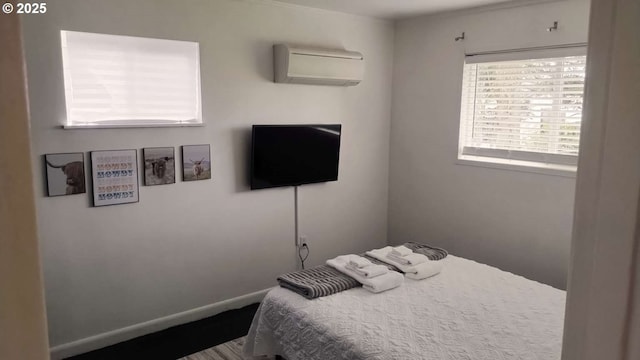 bedroom featuring an AC wall unit and baseboards