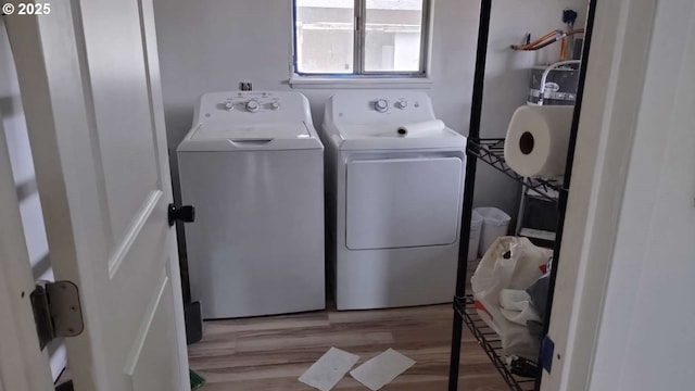 laundry room featuring laundry area, washing machine and dryer, and wood finished floors