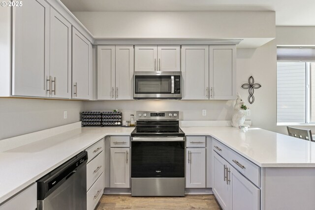 1466 N Steiwer Ln, Newberg, OR 97132 - kitchen featuring light countertops, light wood finished floors, a peninsula, and stainless steel appliances