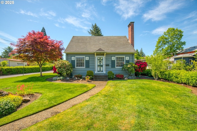 cape cod house with a front yard, a chimney, and roof with shingles