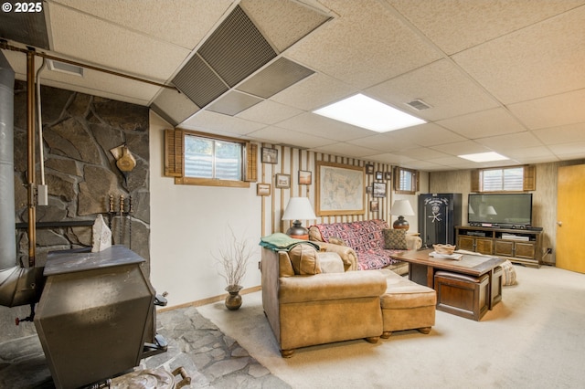 living area featuring a paneled ceiling, carpet, and baseboards