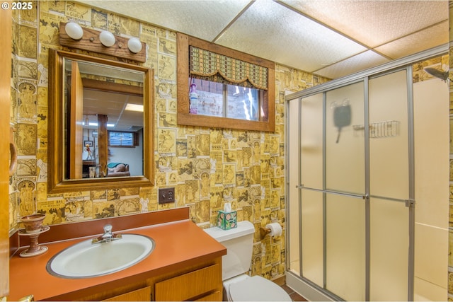 full bathroom with toilet, a shower stall, vanity, and wallpapered walls