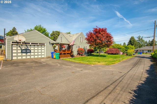 view of front facade featuring a front lawn, a detached garage, and an outbuilding