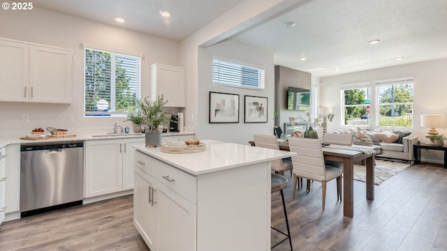 3447 SW Thomas Ave, Gresham, OR 97080 - kitchen featuring stainless steel dishwasher, a kitchen bar, light wood-type flooring, white cabinets, and recessed lighting