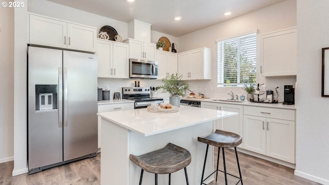 3447 SW Thomas Ave, Gresham, OR 97080 - kitchen with appliances with stainless steel finishes, white cabinets, light wood-style flooring, a kitchen island, and recessed lighting
