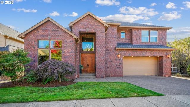 view of front of house with driveway, brick siding, an attached garage, and a front yard