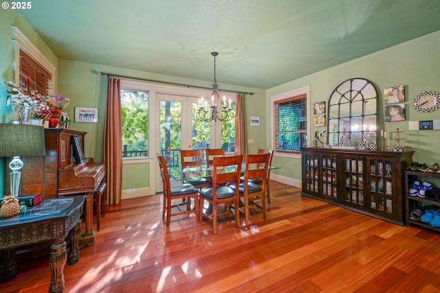 dining room with a notable chandelier, baseboards, and wood finished floors