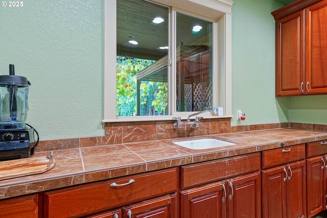 kitchen featuring a textured wall and a sink