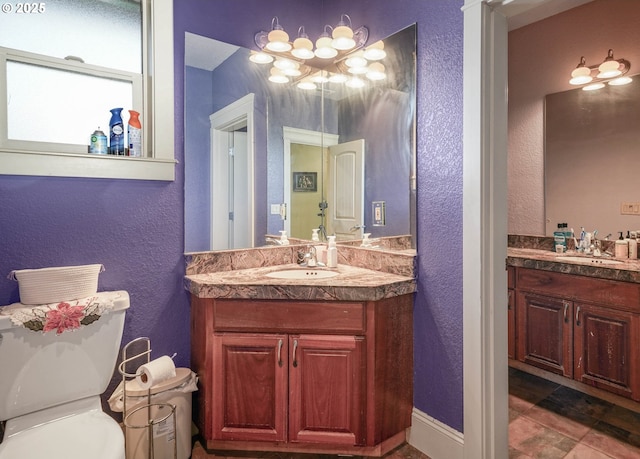 bathroom with toilet, a sink, and a textured wall