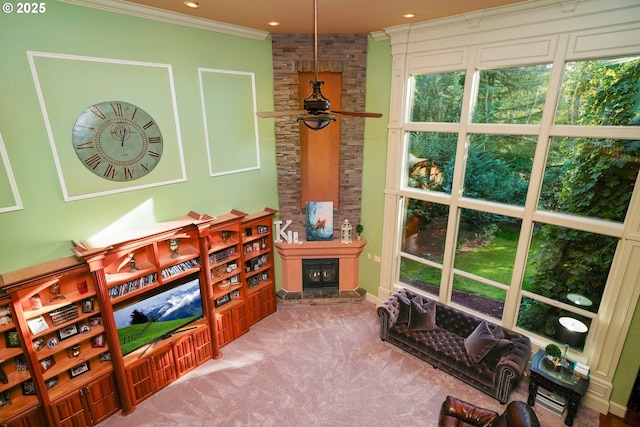 interior space with ornamental molding, recessed lighting, light colored carpet, and a stone fireplace