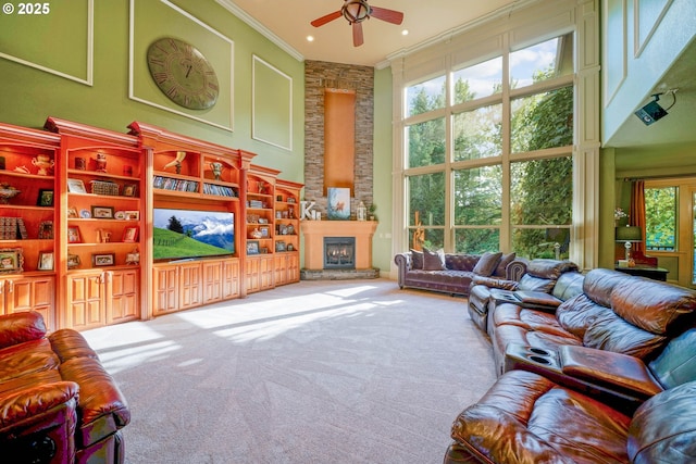 living room featuring a large fireplace, ornamental molding, carpet, a high ceiling, and a decorative wall