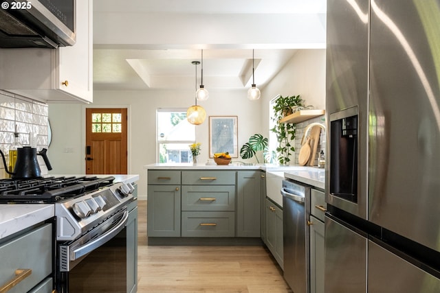 kitchen featuring open shelves, a raised ceiling, light wood-style floors, stainless steel appliances, and a peninsula