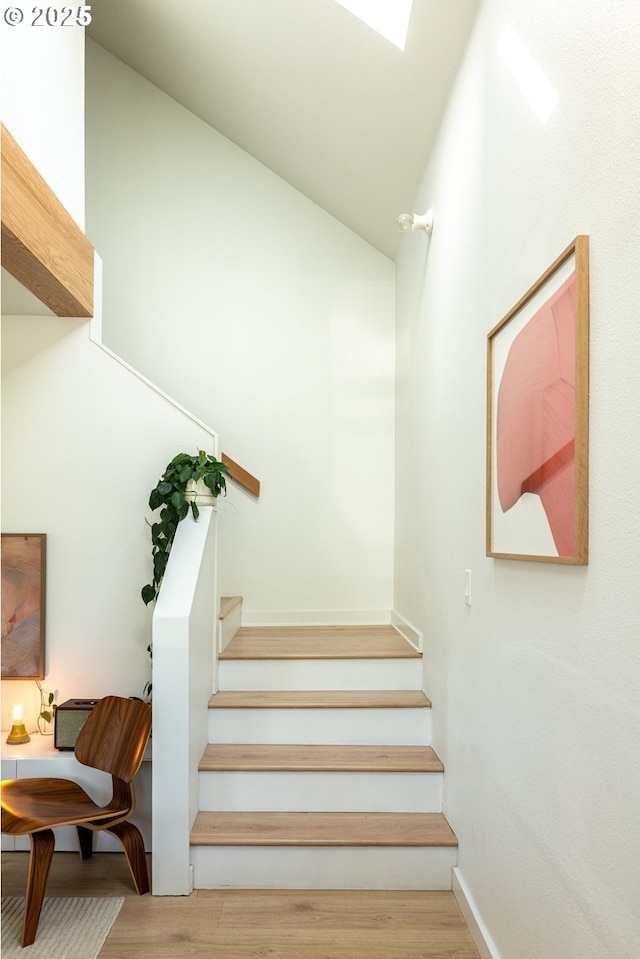 stairway featuring baseboards and wood finished floors