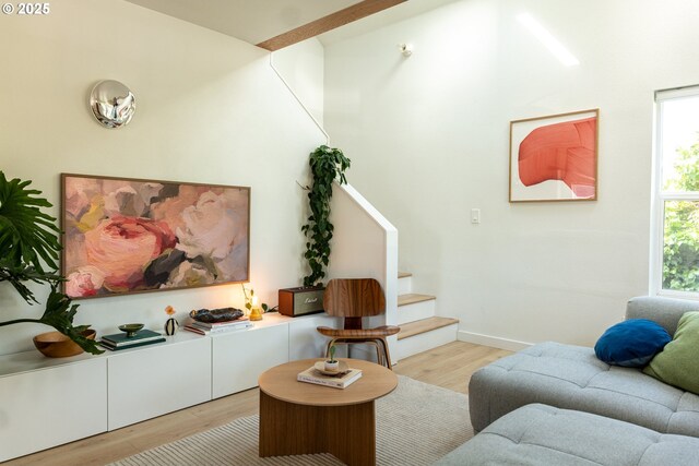 living room with baseboards, stairs, and wood finished floors