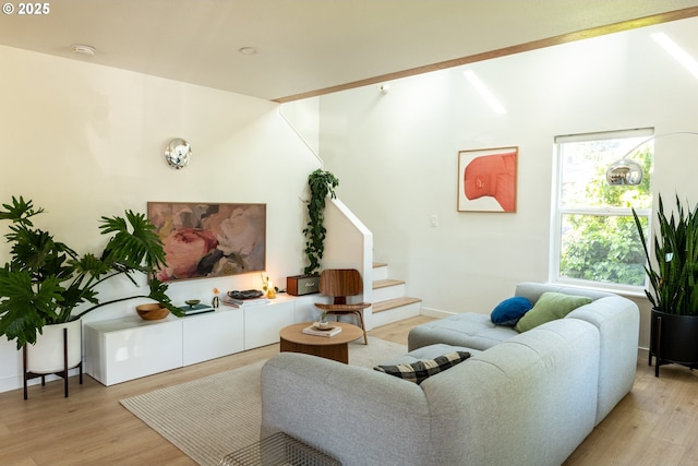 living area featuring stairs and light wood-style flooring