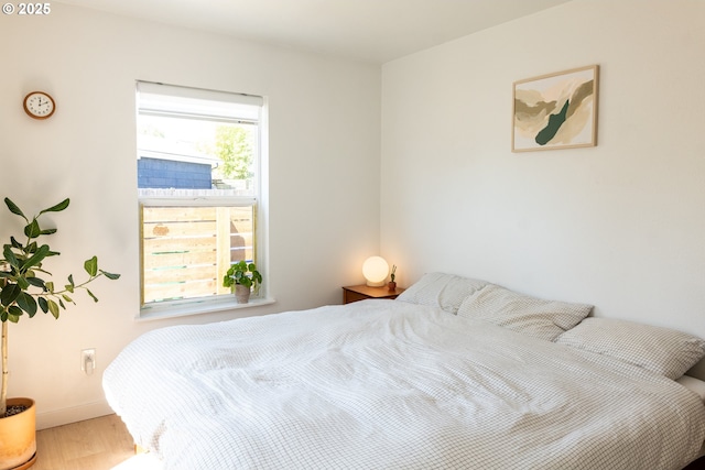 bedroom featuring baseboards and wood finished floors