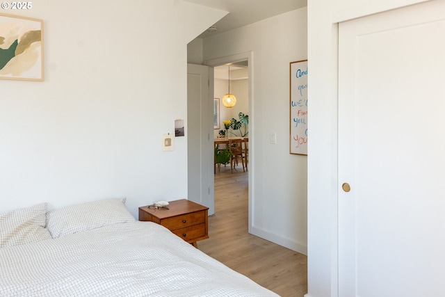 bedroom featuring baseboards, a closet, and light wood finished floors