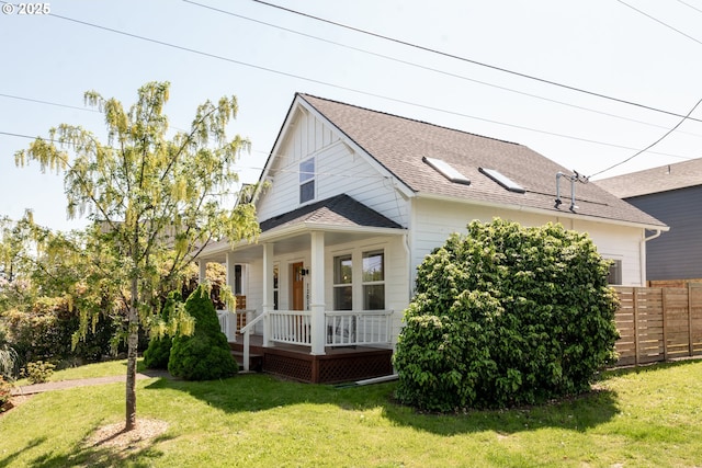 bungalow-style home with fence, a shingled roof, a porch, and a front yard