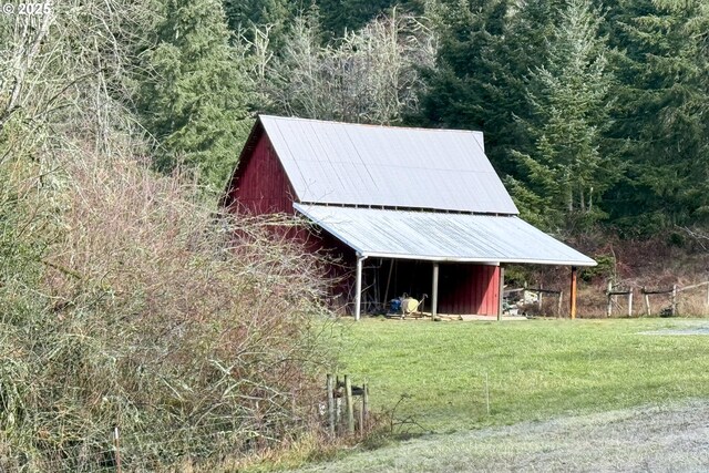 view of outdoor structure with a view of trees and an outbuilding