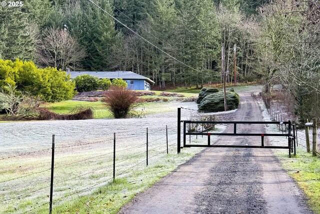 view of gate featuring fence and a forest view