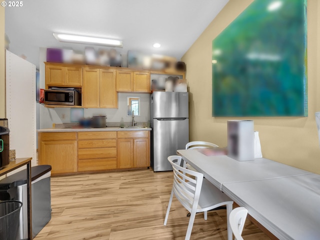 107 Sunset Blvd, Cannon Beach, OR 97110 - kitchen featuring stainless steel appliances, light wood-style flooring, a sink, light brown cabinets, and light countertops