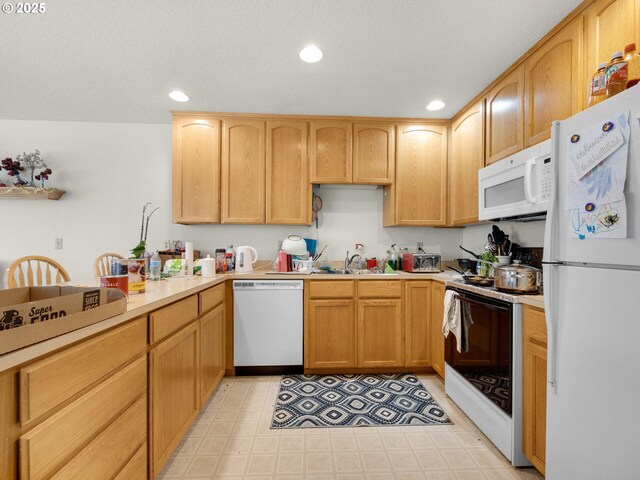 107 Sunset Blvd, Cannon Beach, OR 97110 - kitchen featuring white appliances, a sink, light countertops, recessed lighting, and light brown cabinets
