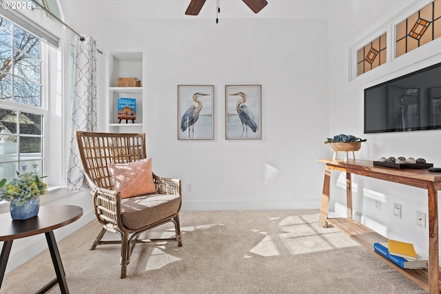 sitting room with ceiling fan, light colored carpet, and a healthy amount of sunlight