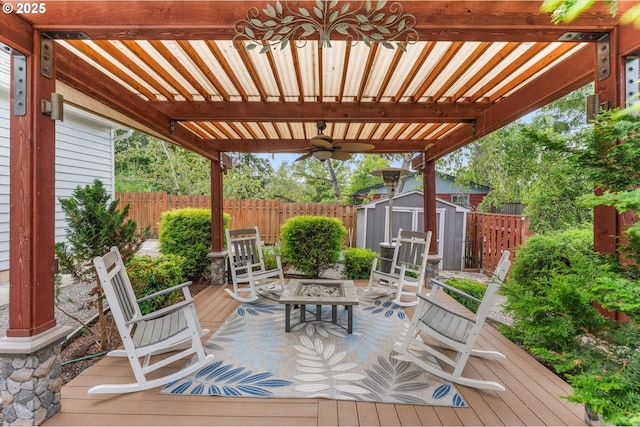 wooden deck with a storage shed, a pergola, ceiling fan, and an outdoor fire pit