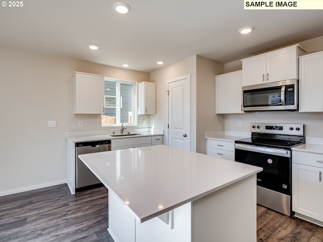 kitchen featuring stainless steel appliances, a sink, dark wood finished floors, white cabinetry, and recessed lighting