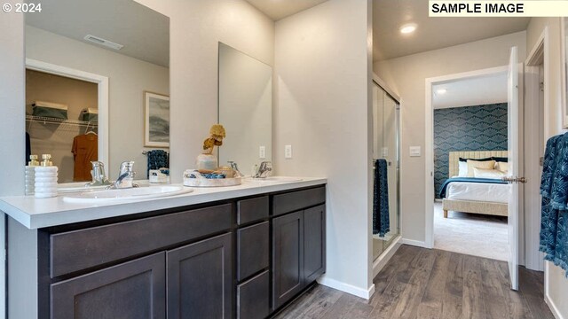 bathroom with walk in shower, wood-type flooring, and vanity