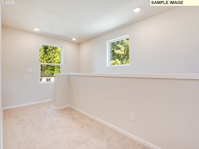 unfurnished room featuring plenty of natural light, baseboards, light carpet, and recessed lighting