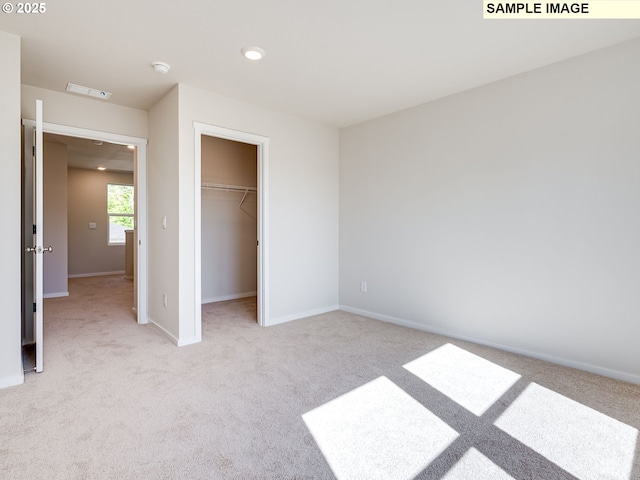 unfurnished bedroom featuring light carpet, recessed lighting, a spacious closet, baseboards, and a closet