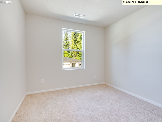 carpeted empty room featuring baseboards