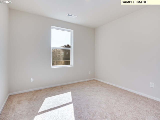 carpeted empty room featuring baseboards