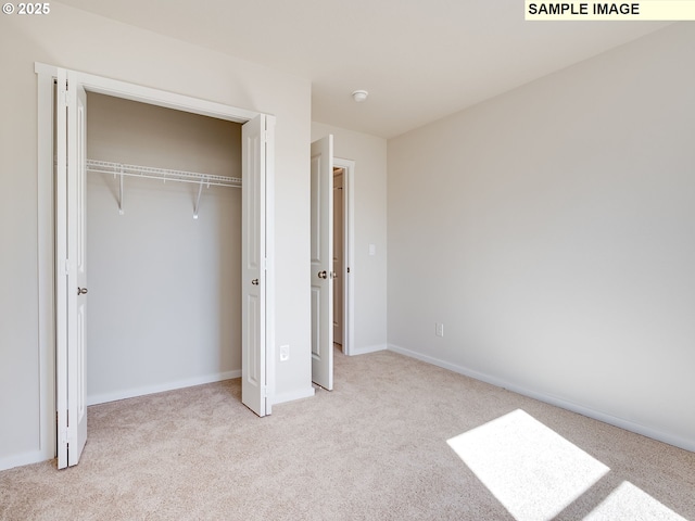 unfurnished bedroom featuring carpet flooring, a closet, and baseboards