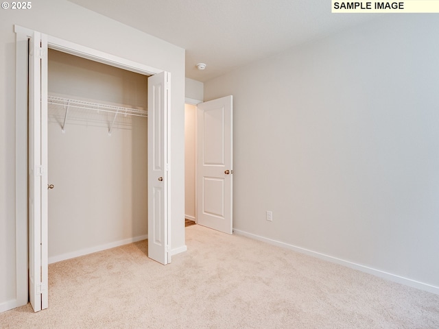unfurnished bedroom featuring carpet floors, a closet, and baseboards