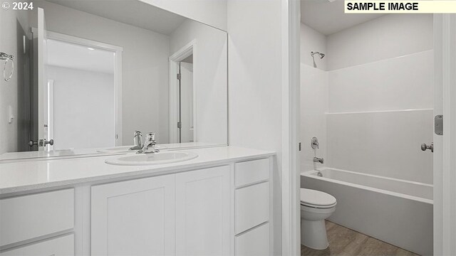 full bathroom with vanity, wood-type flooring, shower / tub combination, and toilet