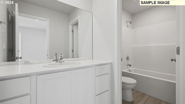 bathroom featuring vanity, washtub / shower combination, toilet, and wood finished floors