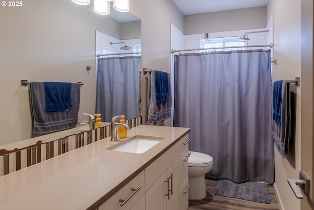 full bath with a shower with curtain, wood finished floors, vanity, and toilet