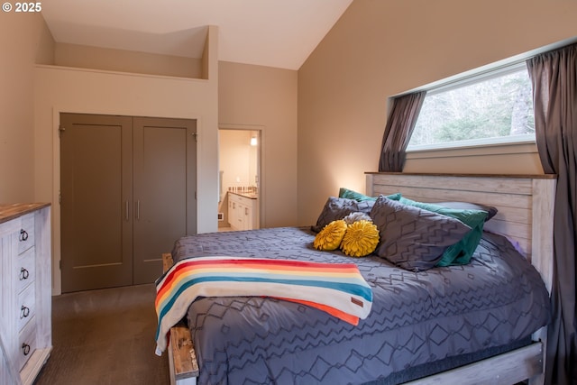 bedroom with vaulted ceiling, carpet floors, and connected bathroom