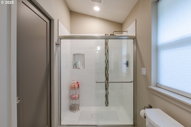 bathroom featuring a healthy amount of sunlight, a stall shower, and toilet