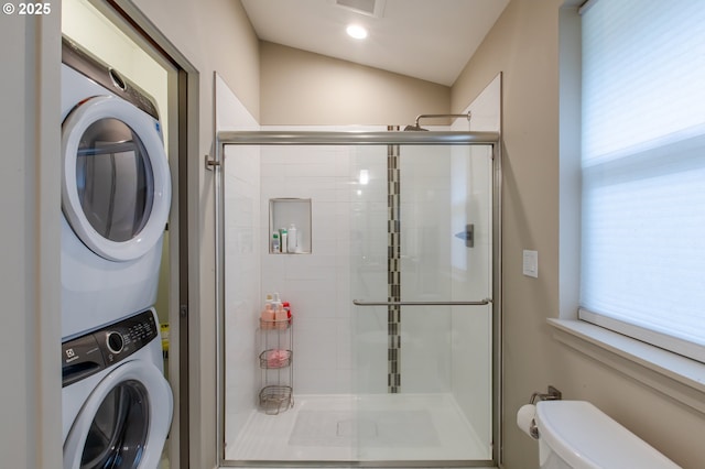 laundry room featuring laundry area, stacked washer and dryer, a healthy amount of sunlight, and visible vents