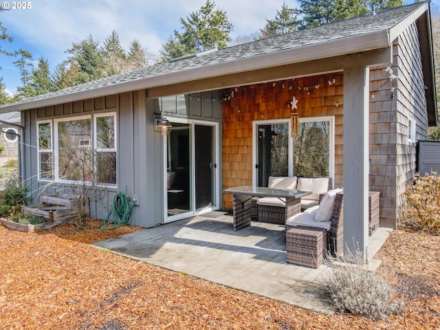 rear view of property with roof with shingles and a patio area