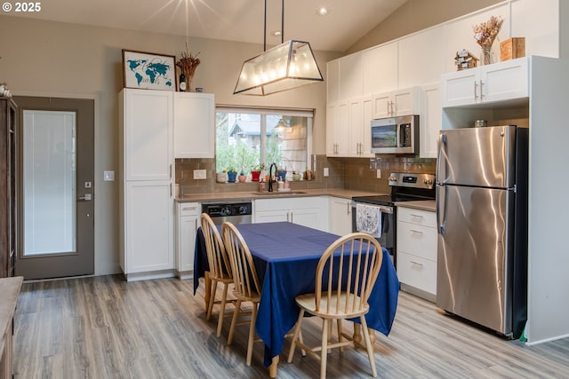 kitchen featuring white cabinetry, tasteful backsplash, appliances with stainless steel finishes, and a sink