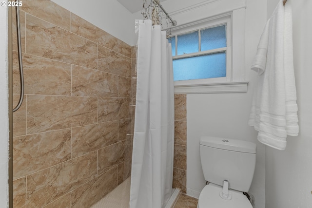 bathroom with toilet and a shower with shower curtain