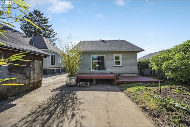 rear view of house with a wooden deck and fence