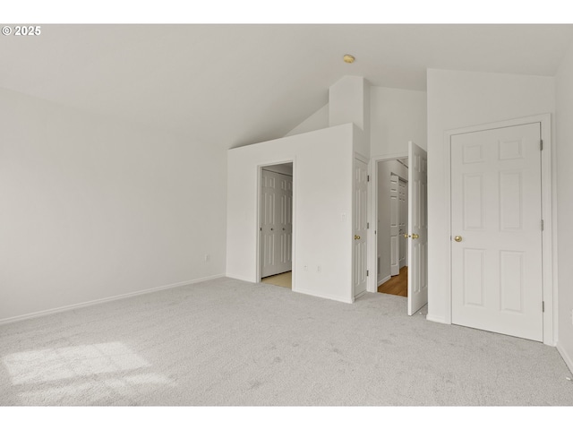 unfurnished bedroom with carpet floors, baseboards, and high vaulted ceiling